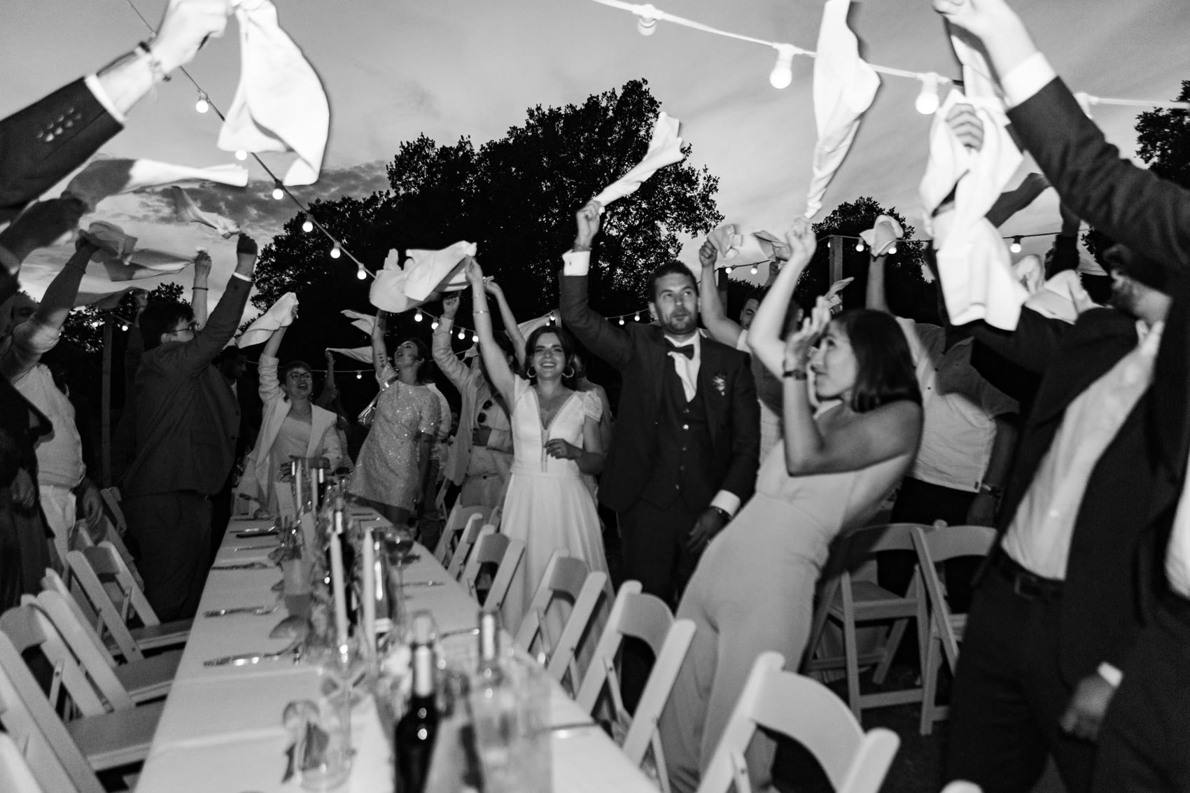 Les invités lèvent les serviettes au crépuscule, mariage en extérieur